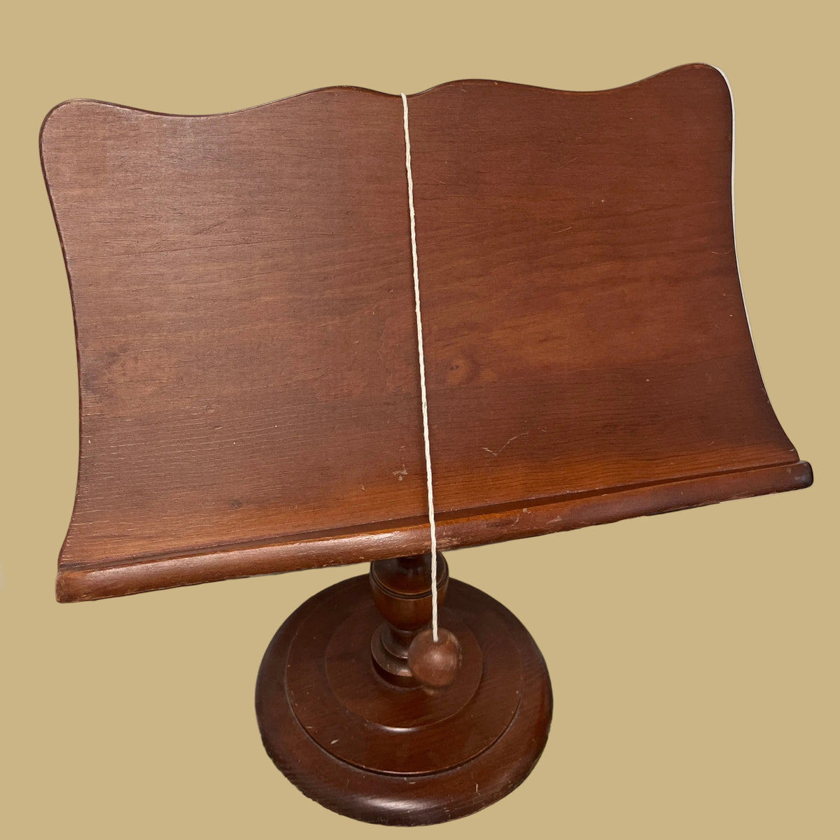 Vintage wooden pedestal bookstand with a turned base and fluted stem.