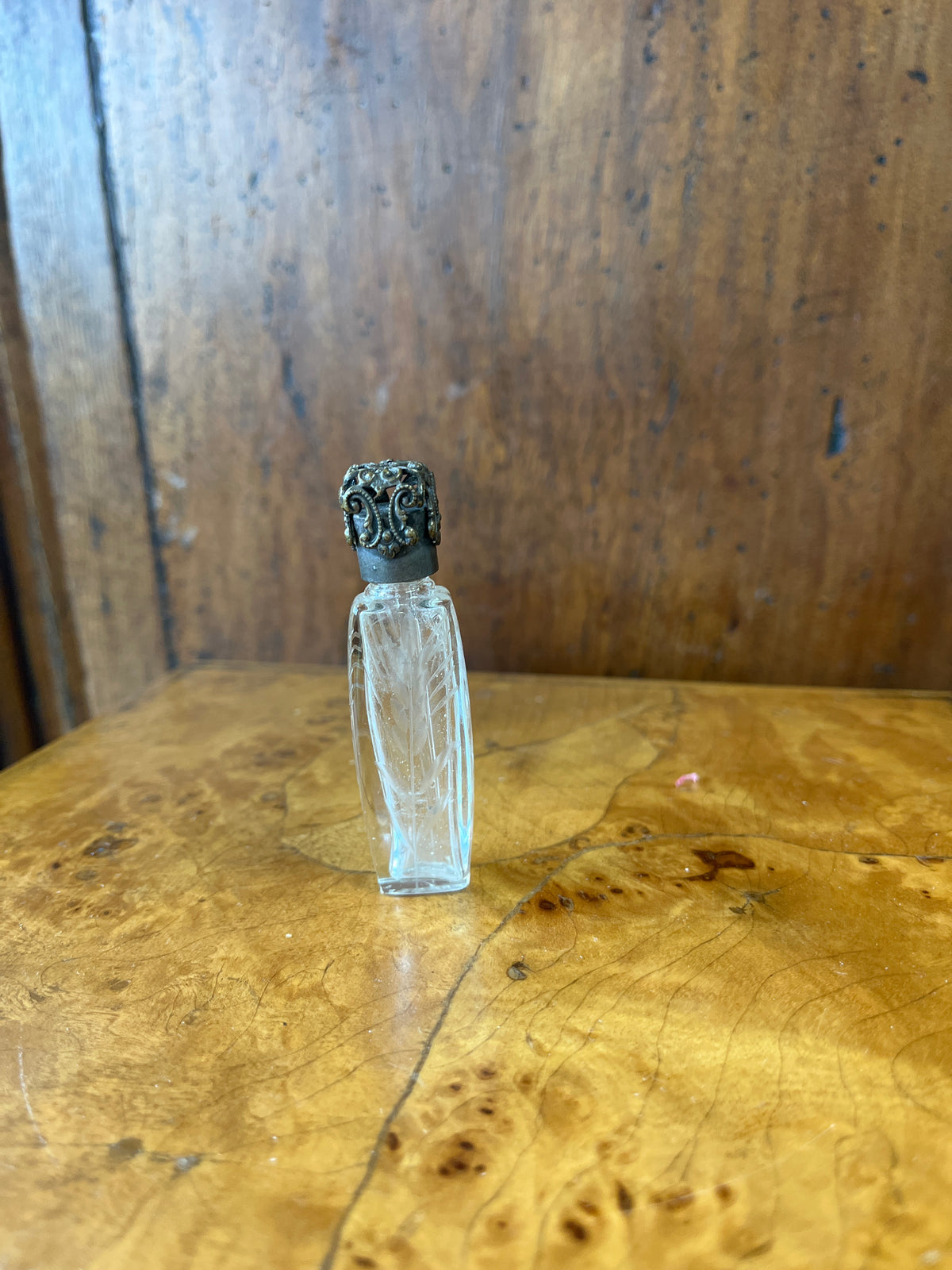 Vintage French etched glass perfume bottle with ornate silver caps.