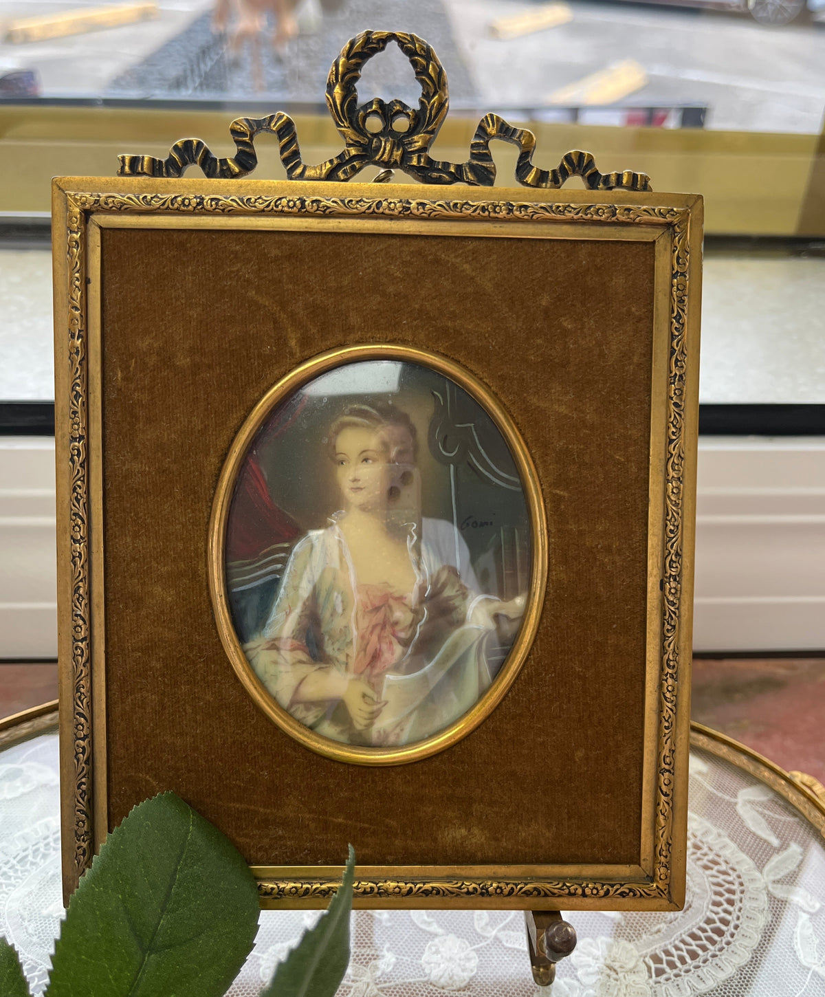 Hand-painted 18th-century miniature portrait of a woman, signed 'Gomi'.
