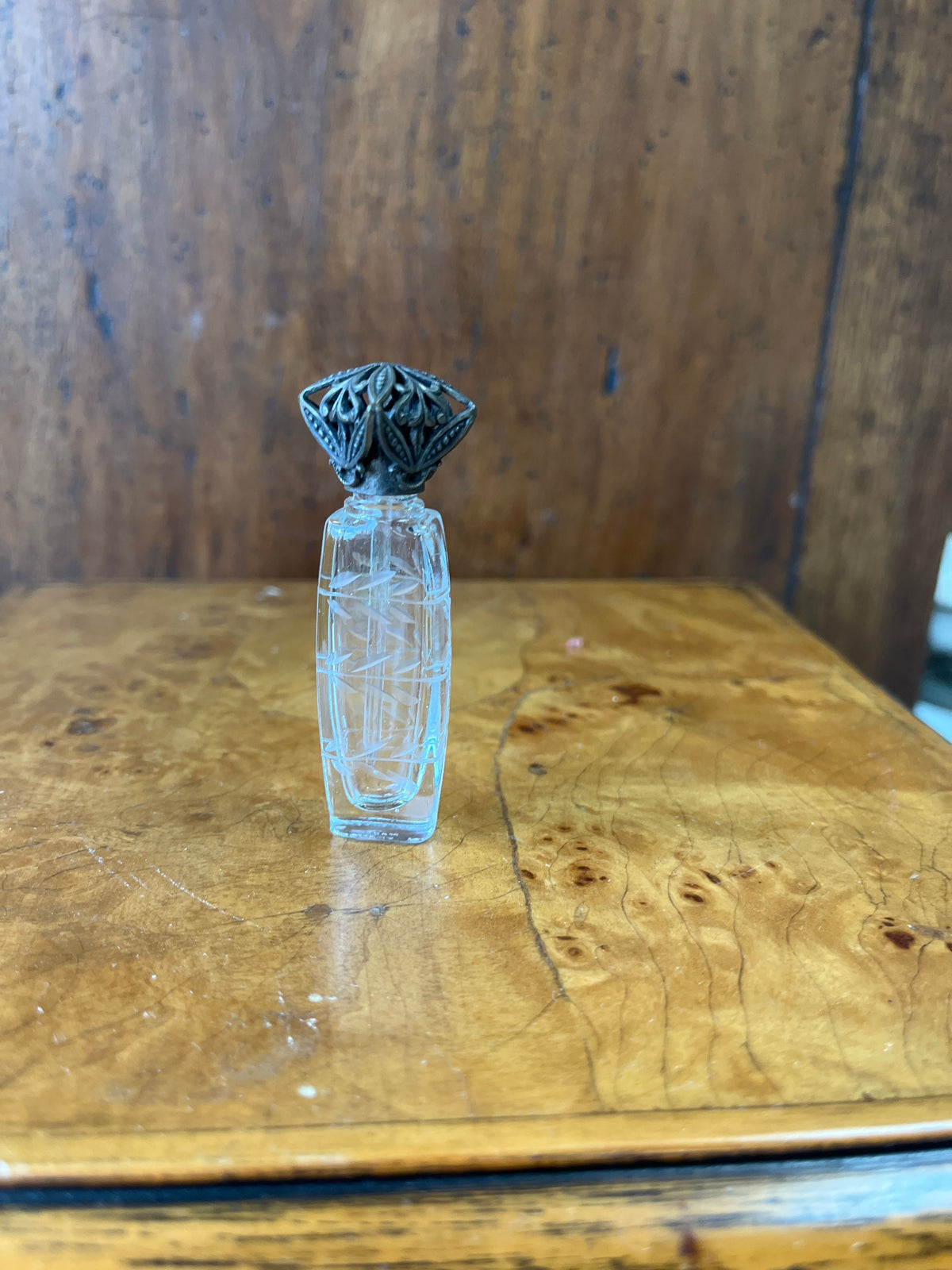 Vintage French etched glass perfume bottle with ornate silver caps.